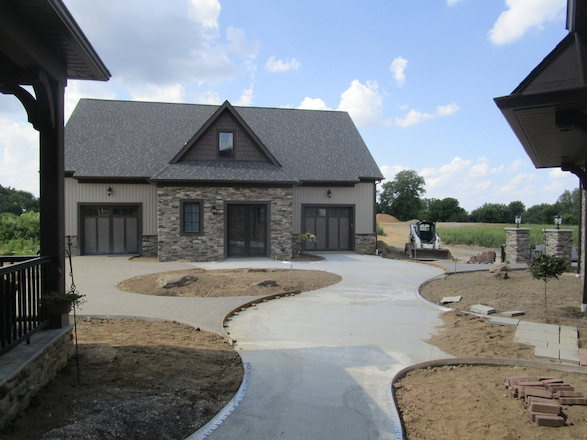 PA bluestone was blended into the clay paver brick to add interest and tie in with the stone veneer on the house. These elements were wed together using meandering curves.