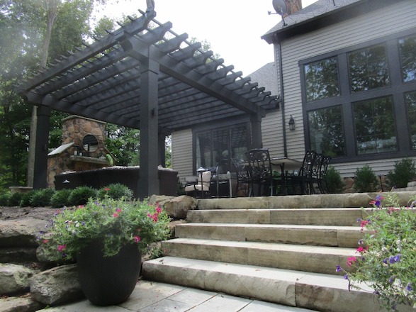 The heavy, masculine feel of the pergola anchors the space visually and establishes a cohesive feel with the style and weight of the home.