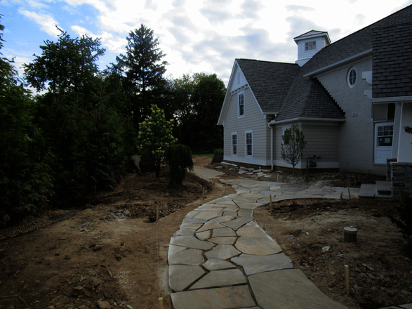 Crews lay out the sweeping, organic curves of the PA Bluestone walkway during construction.