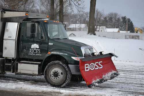 A Rice's truck removing snow on a commercial property